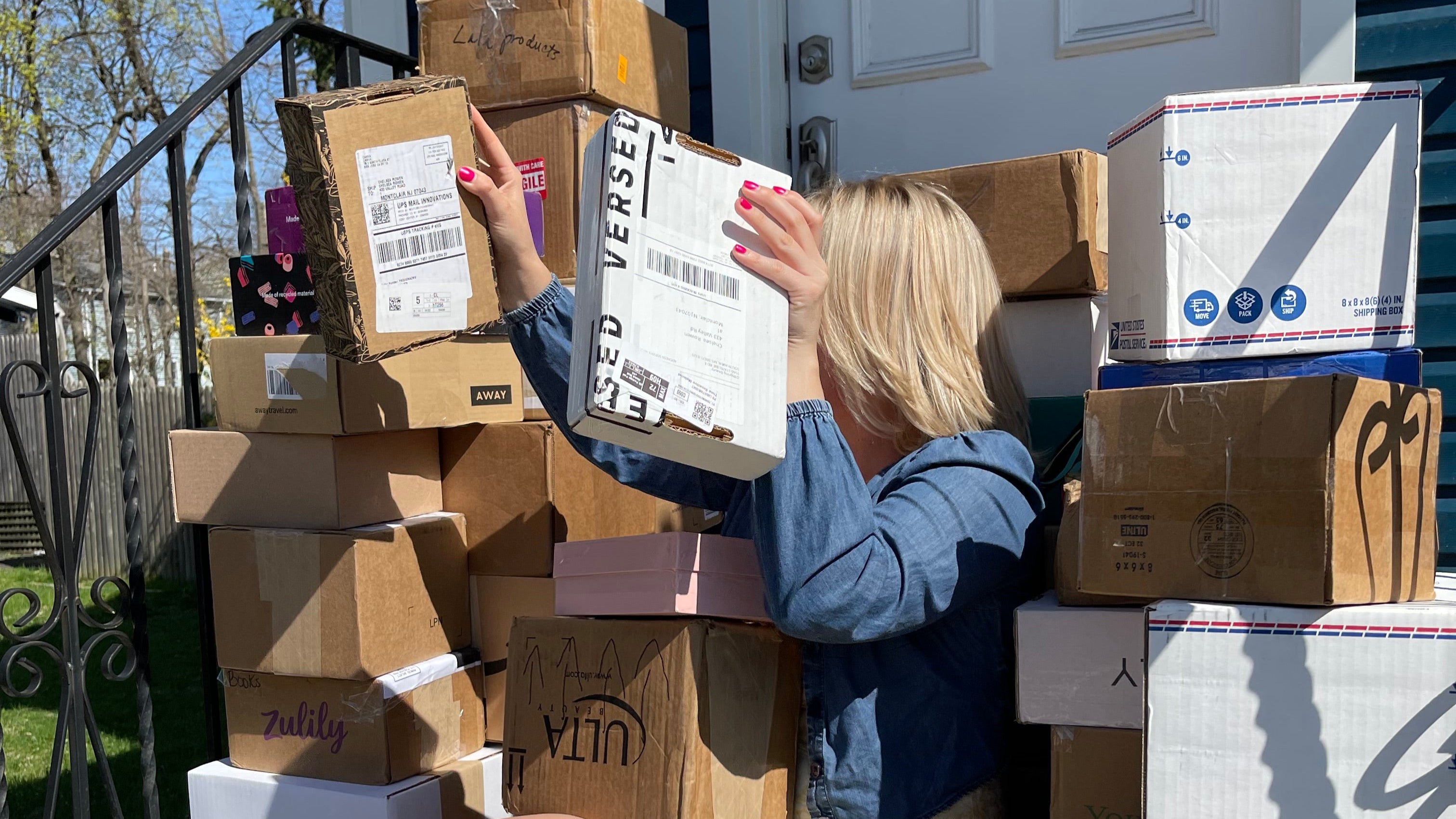 Person reaching into a pile of cardboard boxes on a ladder